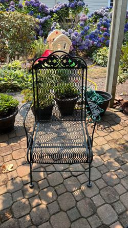 Two green wrought iron rocking chairs