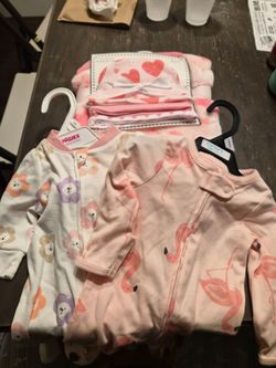 2 baby outfits, 3 hats, and a blanket