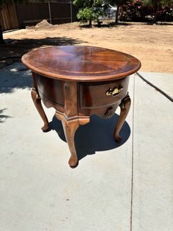 Vintage Hekman French-style side table featuring a burl walnut top, carved cabriole legs, and brass hardware $10