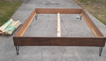 Mid-century modern style Queen bed frame features tapered hairpin legs and a warm, dark wood finish
