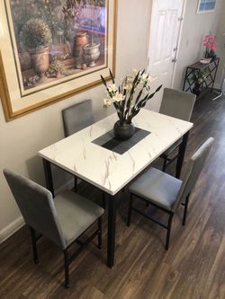 White faux marble dining table set with 4 gray fabric chairs