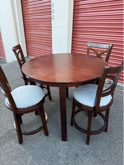 Round wooden high table and four chairs