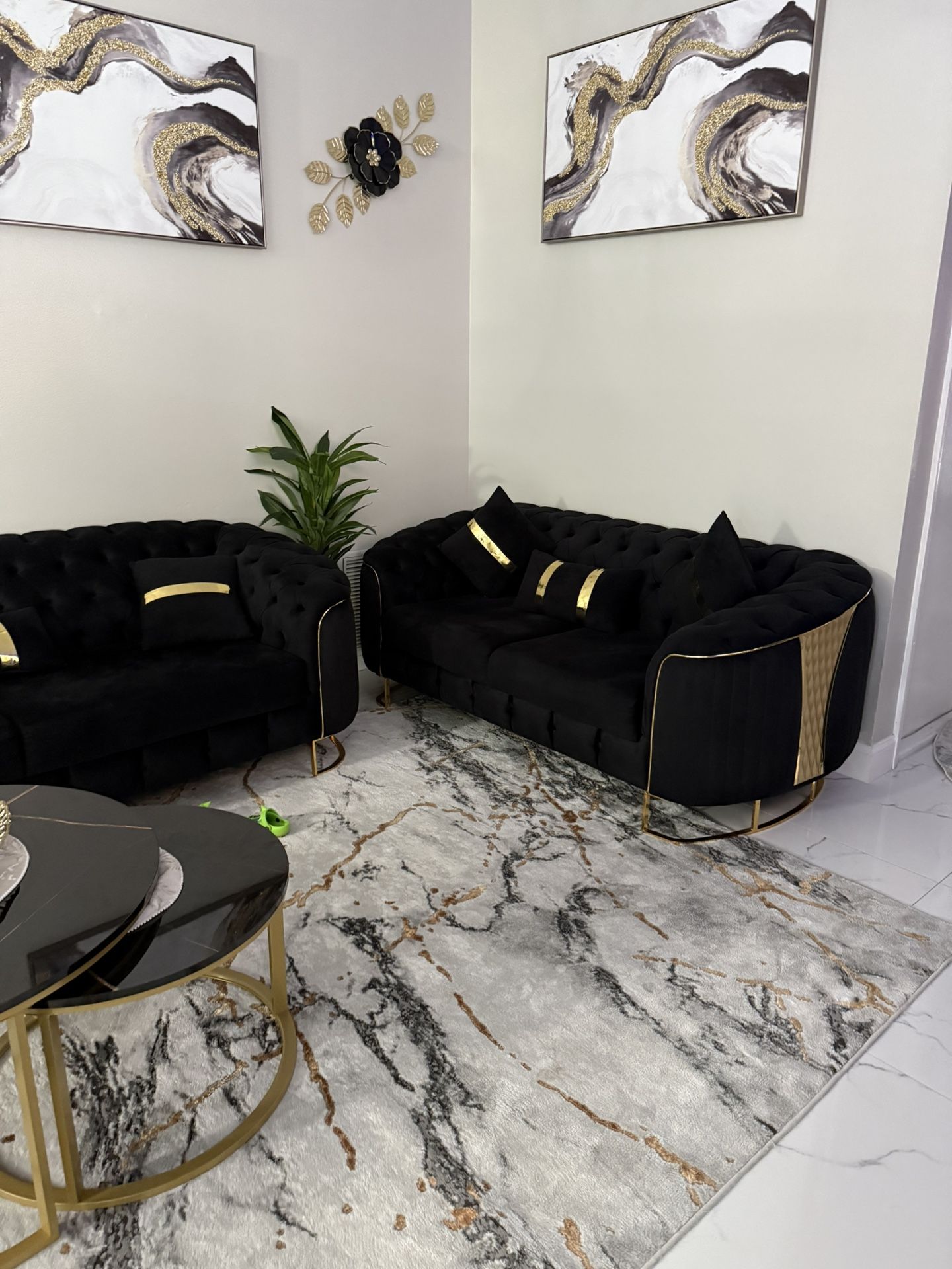 black and gold sofa and a set of tables