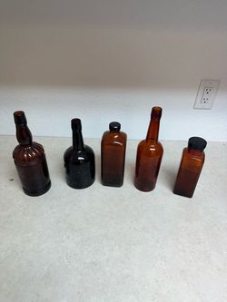 This is a collection of late 19th-century antique amber glass whiskey and apothecary bottles.