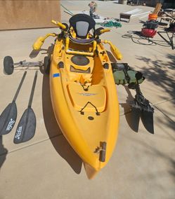 Yellow Hobie kayak equipped with stabilizing buoys.