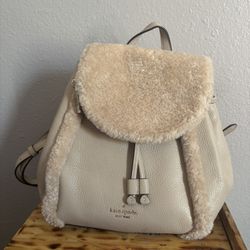 Kate Spade Leila Medium Flap Backpack with faux shearling in the color Light Sand