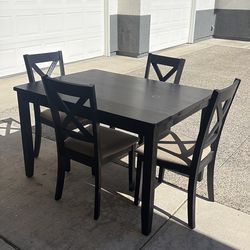 Black dining table with four chairs