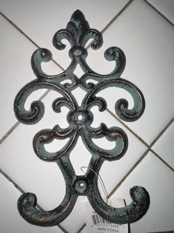 VINTAGE CAST IRON SCROLLWORK DOUBLE WALL HOOKS IN TEAL AND HIGHLIGHTS OF GOLD.