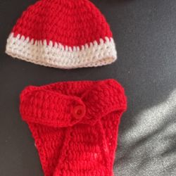 Adorable crochet baby set featuring a red and white hat with a matching diaper cover. Perfect for keeping your little one cozy and stylish.