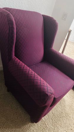 Two classic burgundy wingback armchairs