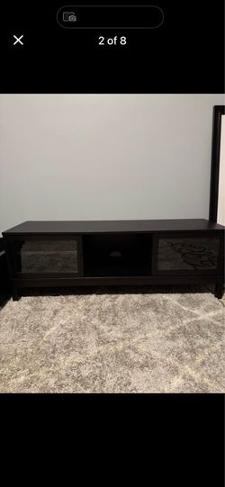 Dark brown, medium entertainment console was slidding glass doors