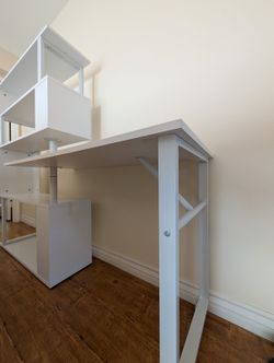 Modern white desk with integrated shelving.