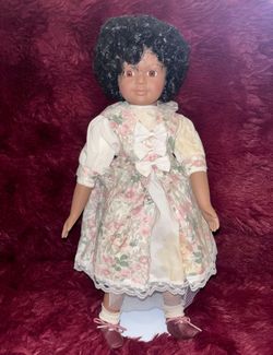 Sweet Essence" porcelain doll with a caramel complexion, curly black hair, and a floral dress 15-inch