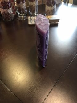 Ellipsis shaped purple hand made candle. The scent is grape and juicy pear
