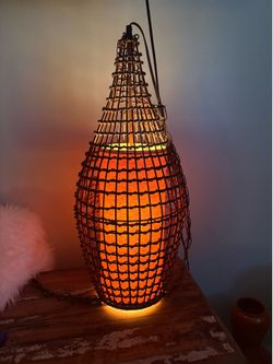 This is a vintage 1970s mid-century modern wicker swag lamp.