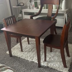 a table, two chairs for a child, and a large chair for resting, made of good wood.