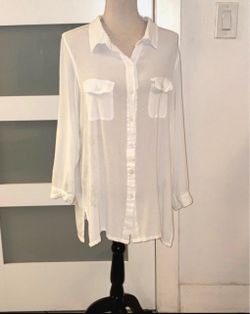 A white button-down blouse, a classic basic with a utilitarian or safari style thanks to its characteristic double flap pockets on the chest. Ralph La