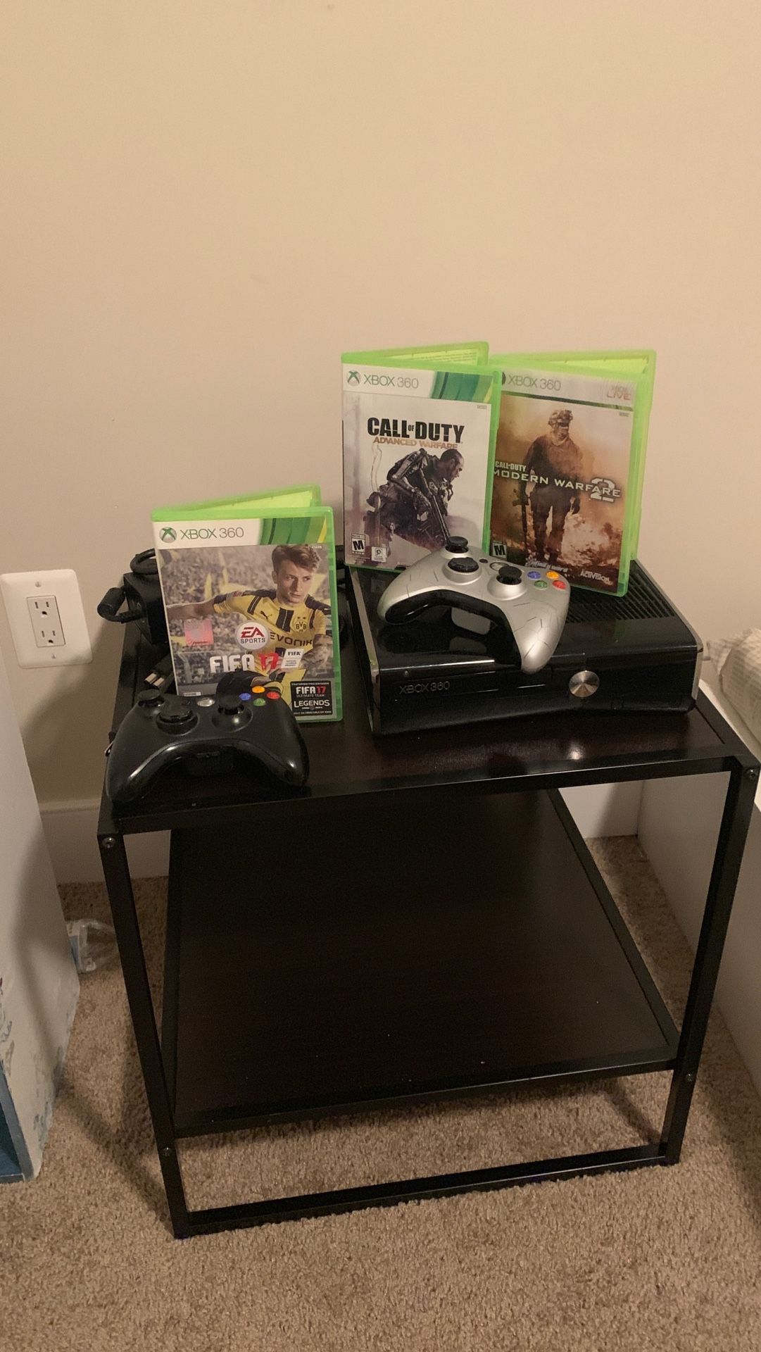 Xbox 360 with three games and two controllers And the table