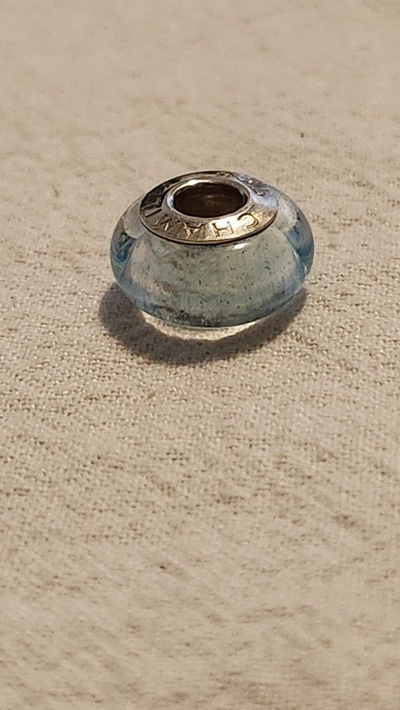 NEW Authentic Chamilia Murano Glass Charm Bead. Clear with Blue Ribbon. Sterling Silver. Hallmarked CHAMILIA 925. 90% of Chamilia charms fit Pandor
