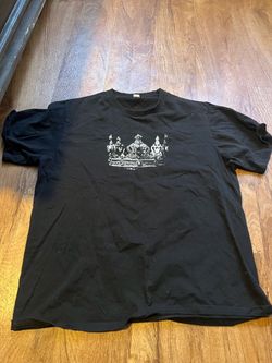 Black t shirt with crown decal and waving priest guy