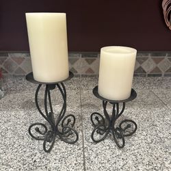 Pair of black metal candlesticks 12” and 9” tall with white battery operated wax feel candles and working batteries! 