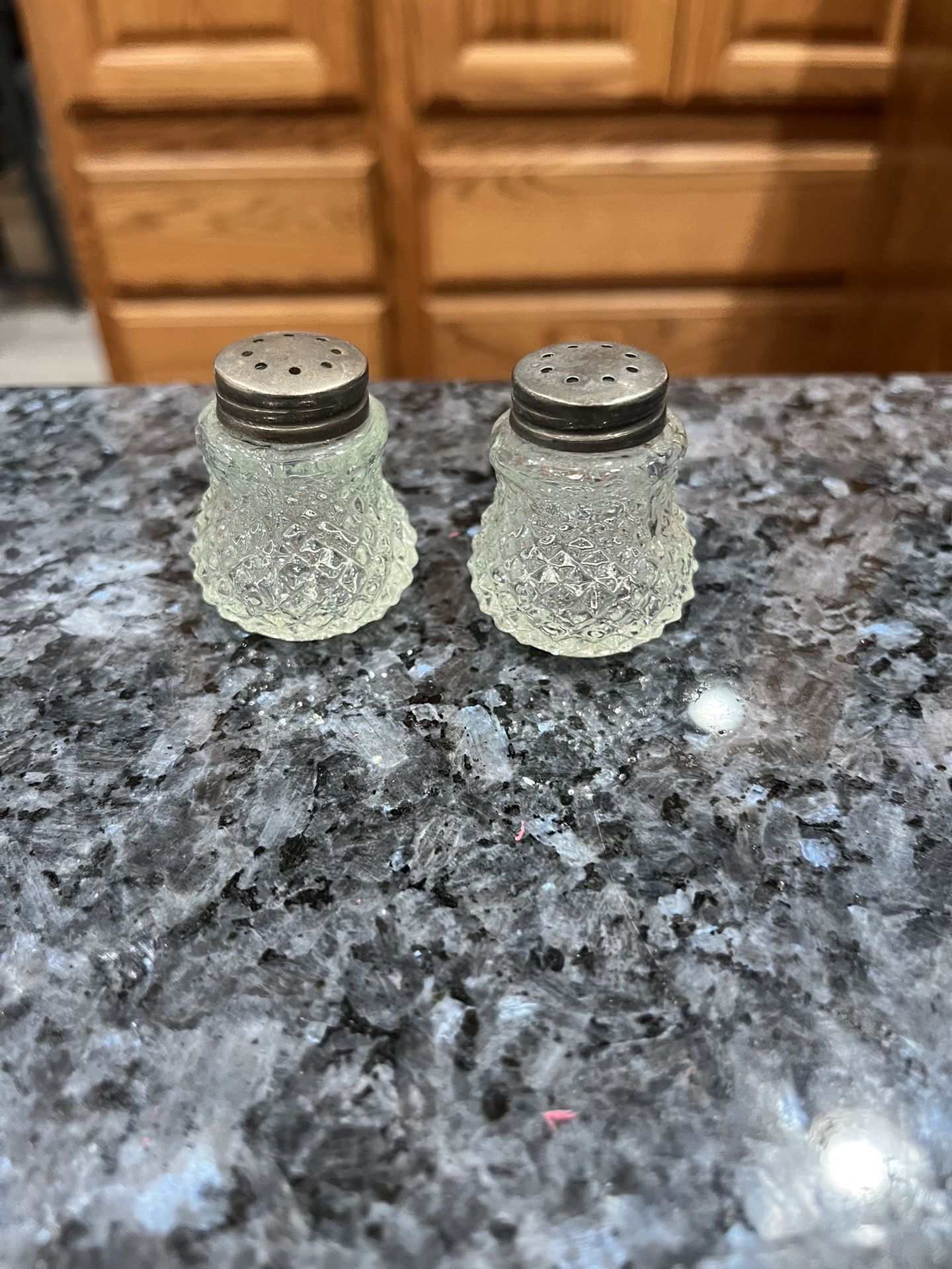 Vintage Glass pair of salt and pepper shakers. Size approximately 1 1/2 inches tall. Preowned .
