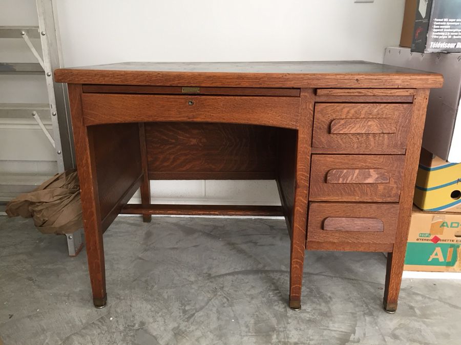 Antique oak desk. Great condition. All original. Has a black top, three side drawers, one center drawer, and a pull out side writing surface.