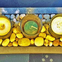 Blown Colored Glass Candle Holder Laid In Stones on Wooden Tray