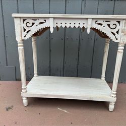 Rectangular console table is constructed using fir and manufactured wood. Console and entry table has a decorative scroll front. Table has a slightly 