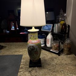 A beautiful antique Asian ceramic lamp, featuring a captivating Phoenix design with a mesmerizing blend of pink and yellow floral patterns, is for sal