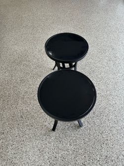 Two round metal tables with smoked glass