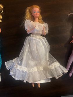 Vintage Barbie doll is dressed in a white satin and lace wedding gown