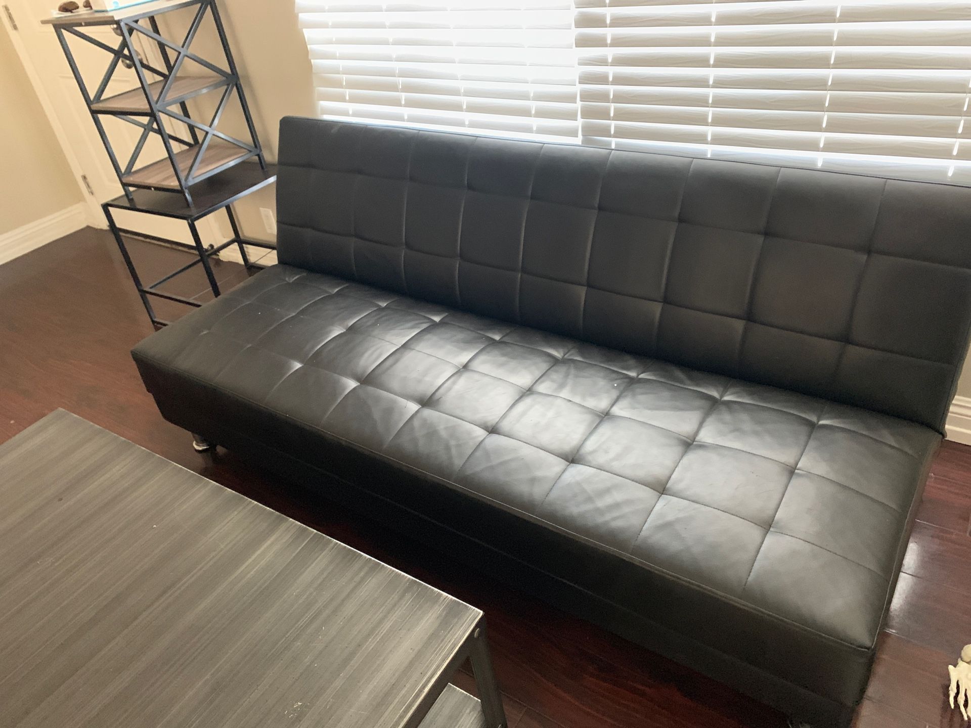 Fold out futon . Black leather