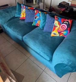 Turquoise plush couch with stable non motion couch cover, and accent pillows