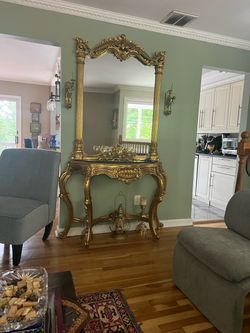 Ornate gold mirror with console table