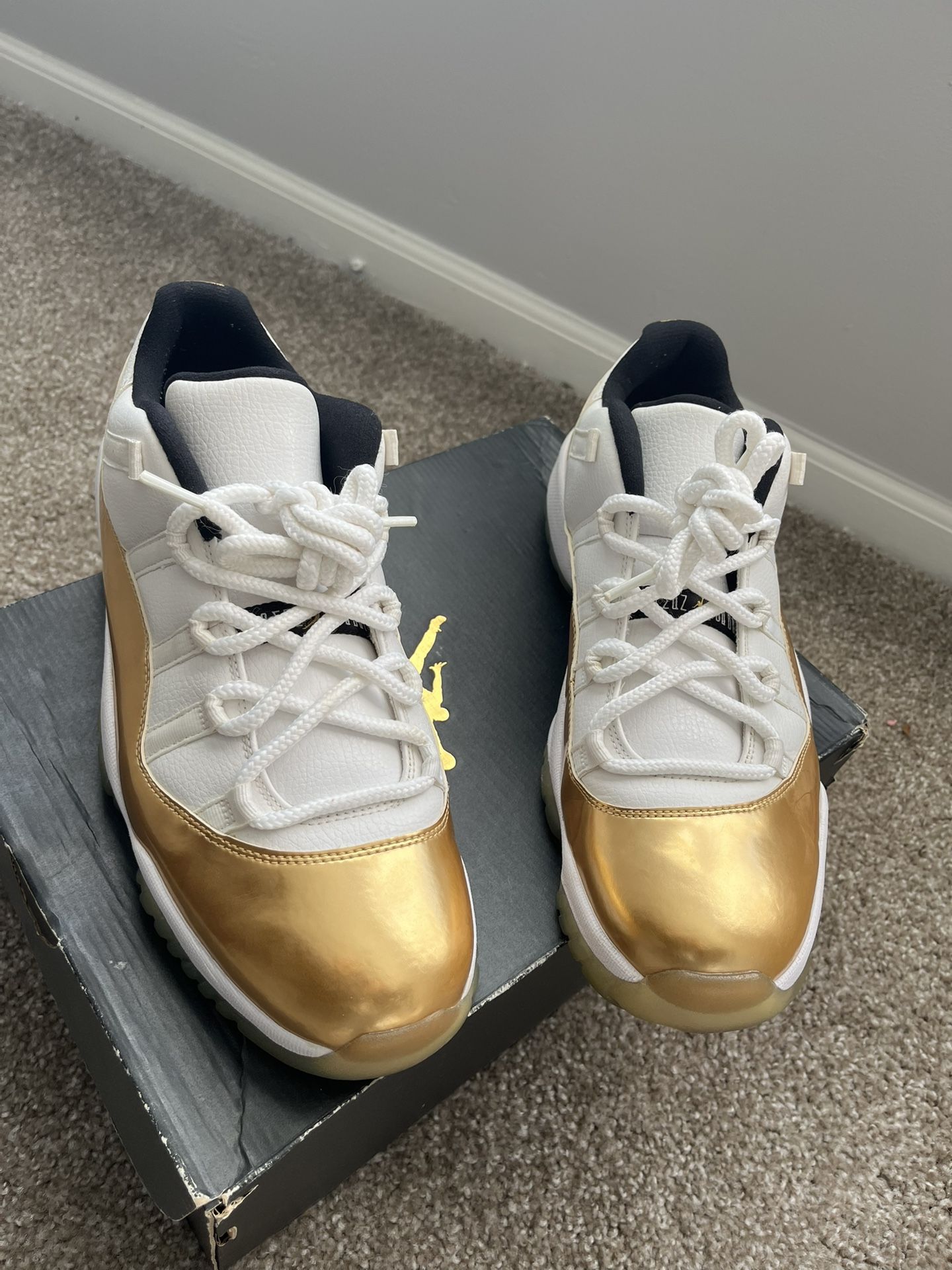 Nike Air Jordan 11 Retro Low "Closing Ceremony" sneakers in white, metallic gold, and black.