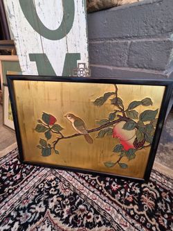 An elegant Asian-style decorative panel featuring a hand-painted design of birds and pomegranates on a gold-leaf background, set in a black frame.