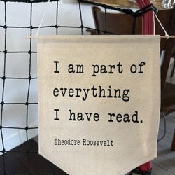 Canvas wall hanging banner features a famous typewriter-font quote by former U.S. President Theodore Roosevelt