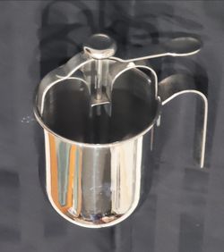 Stainless steel batter dispenser or funnel pitcher used for portioning pancake, waffle, or cupcake batter.