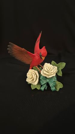 A Lenox porcelain figurine of a cardinal with white roses and a ribbon.