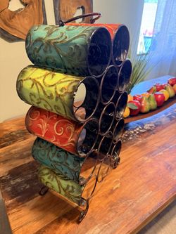 Pier 1 embossed metal wine rack in earth tones like teal, green, and Tuscan orange