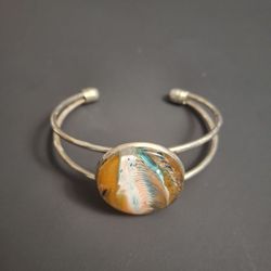 Unique Handmade Acrylic Pour Cuff Bracelet W/Vibrant Abstract Design W/Swirling Orange, White & Teal Patterns Under A Glass Cabochon