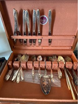 This appears to be a vintage Oneida Ltd. 1881 Rogers or Tudor Plate silverware set.The flatware features an elegant raised floral pattern on the handl