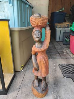 Hand carved woman holding basket