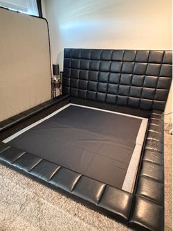 Black king size bed frame for sale. Modern upholstered design with tall padded headboard and matching frame.