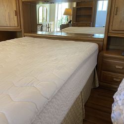 Oak queen sized bed with Storage cabinets and mirror.