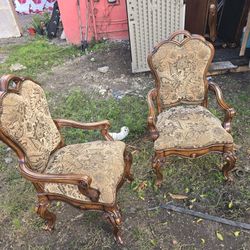 antique English Victorian walnut armchair with ornate carvings and a brown paisley-patterned fabric.