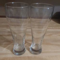 two tall, clear glass tumblers, likely designed for beverages