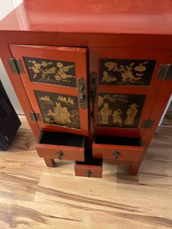 Chinese red lacquered cabinet gold hand-painted figural scenes and botanical motifs on double doors