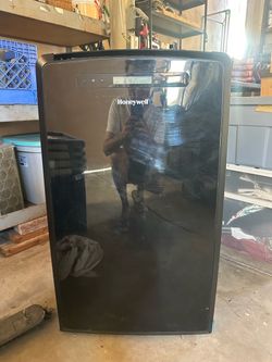 The image shows a black Honeywell Portable Air Conditioner, which functions as a 3-in-1 unit featuring cooling, dehumidifying, and fan modes.